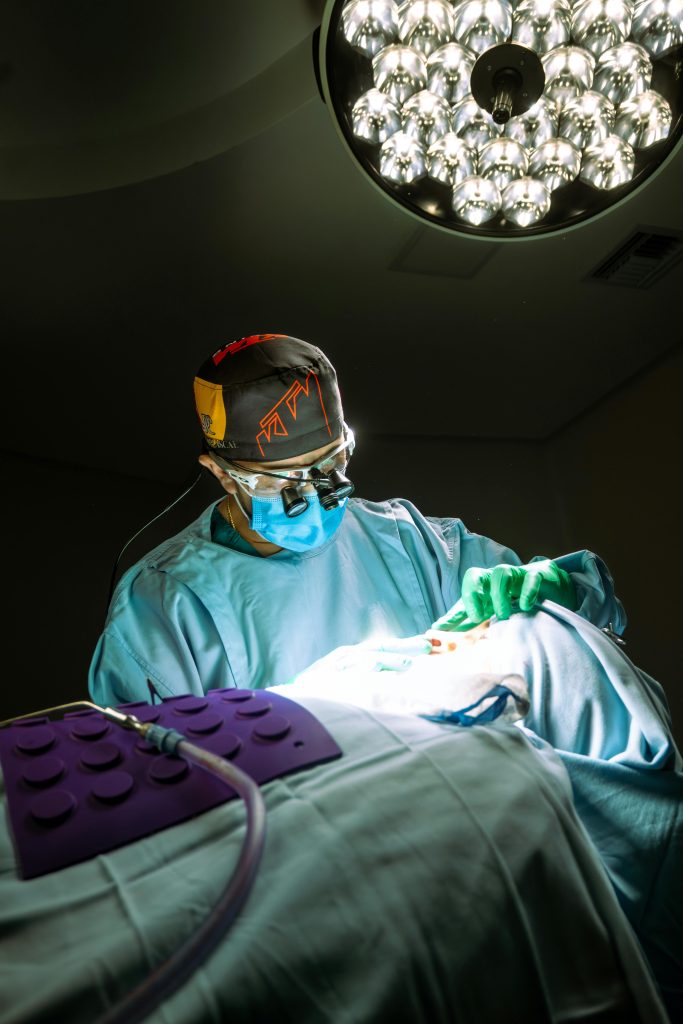 pexels-photo-30686718-30686718 Focused surgeon performing rhinoplasty under bright surgical lights in a sterile operating room.